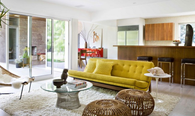 A living room with a yellow rattan couch.