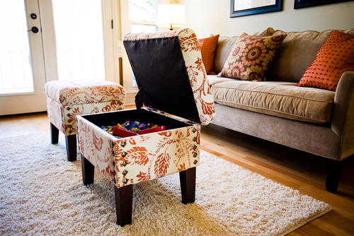 A small ottoman sitting on a rug in a stylish living room.