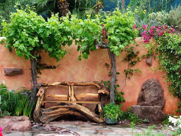 A wooden bench enhances a garden with vines growing around it.