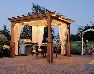 A wooden gazebo with lights, grill, and curtains.