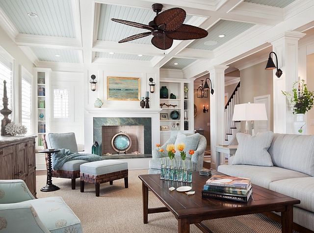 A stylish living room with a ceiling fan and couches.