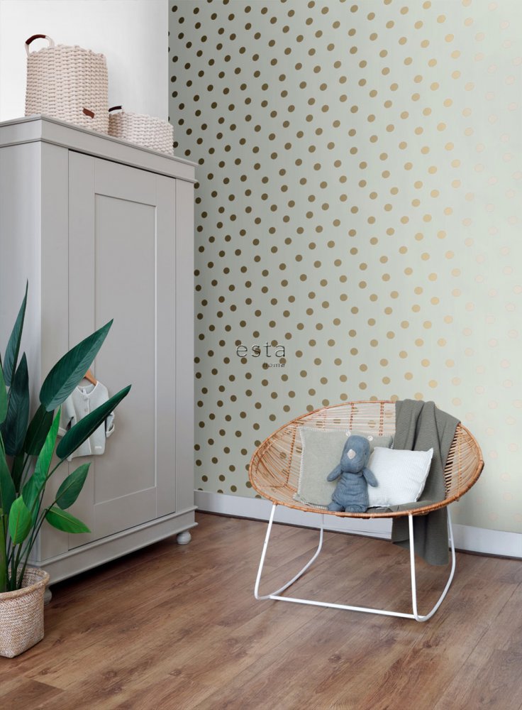 Modern nursery with polka dot wallpaper and wicker chair.