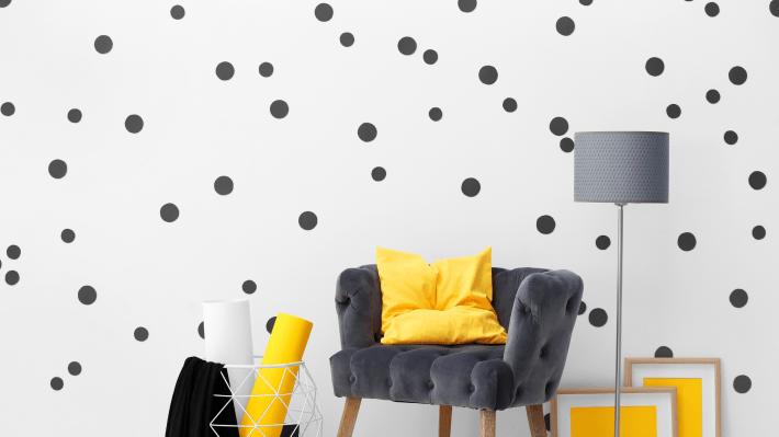 Modern room with polka dot wall and yellow accents.