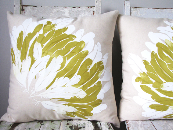 Two feather pillows adorned with green and white flowers, perfect for feathering your nest.
