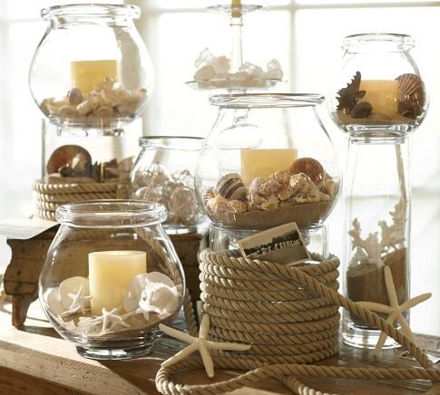Decorating with candles and seashells: jars on a table.