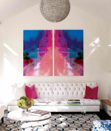 A living room with two large watercolor paintings on the wall.