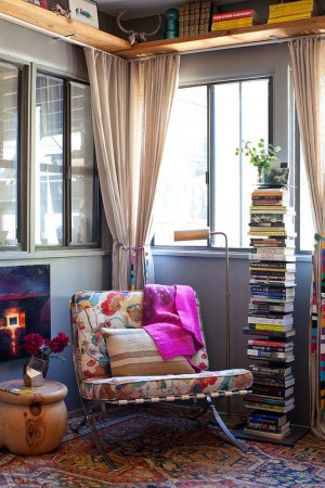 A living room with a colorful rug and bookshelves, showcasing stylish home decor.