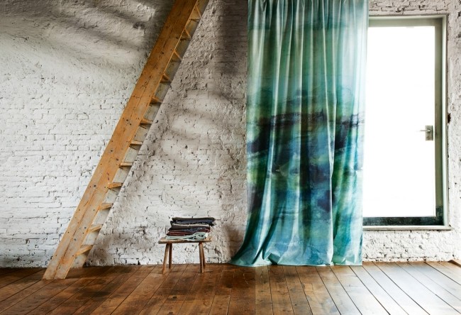 A room with a blue curtain showcasing a watercolor design style.