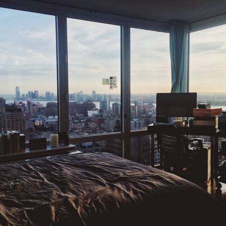 A splendid bed with a view of a city.