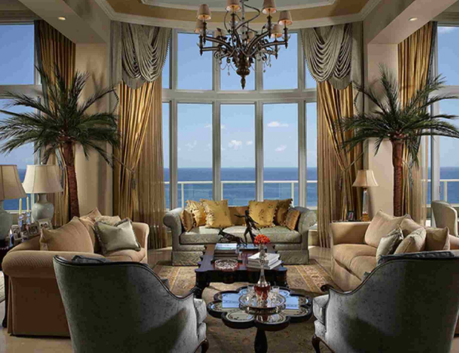 A living room with a view of the ocean and gold accents.