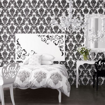 A monochrome bedroom with a black and white damask wallpaper.