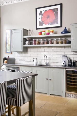 A kitchen with open shelving and striped stools.