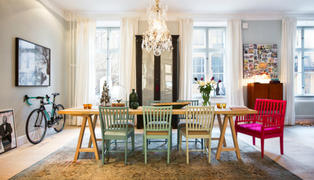 A dining room with colorful chairs and design inspiration from Scandinavian style homes.