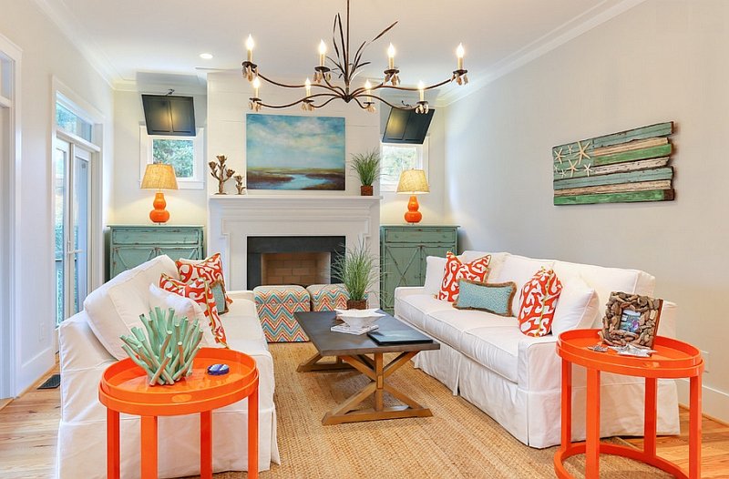 A living room with white furniture and coral accents.