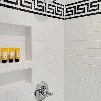 A bathroom with a black and white tiled shower featuring Greek Key design.