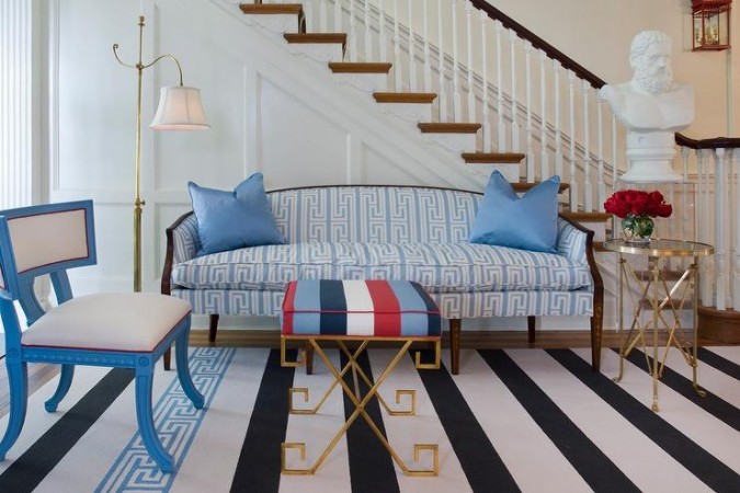 A blue and white striped rug with a Greek Key design in a living room.