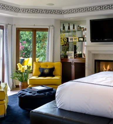A bedroom with yellow chairs and a fireplace features Greek Key Design in its interiors.