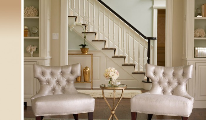 Two gold chairs in front of a staircase.