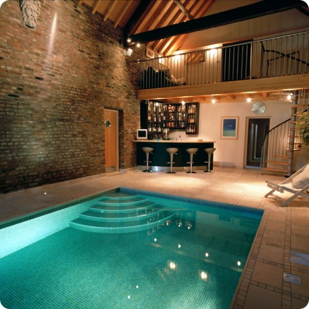 Backyard pool parties are great, but adding entertaining areas to an indoor pool space helps 