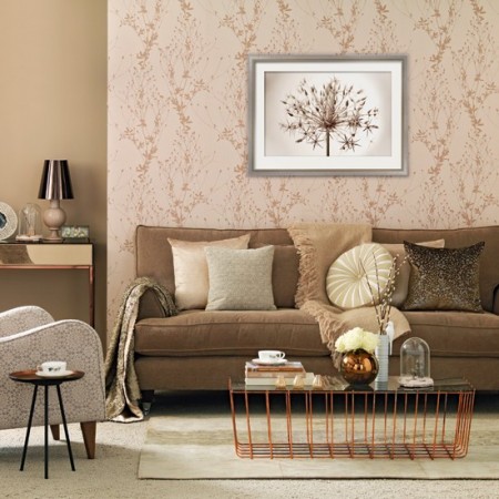 A living room with beige furniture and a framed picture adds gold accents.