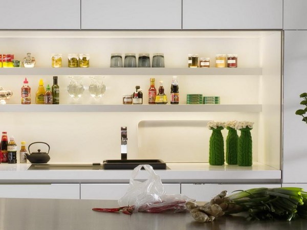 A white kitchen with open shelving and a lot of food on the counter.