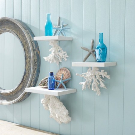 A blue wall with ocean accents and a mirror.