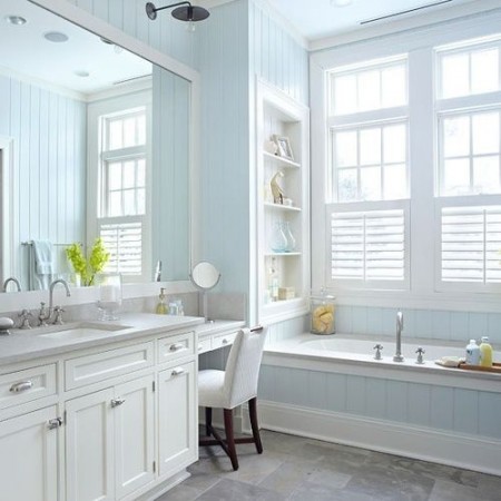 A bathroom with light blue walls and a white vanity, perfect for creating a pastel look.