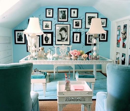A stylish home office design for her with blue walls and pictures on the wall.