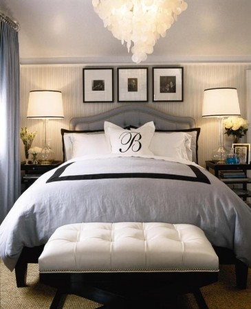 A monogrammed black and white bedroom with a chandelier.