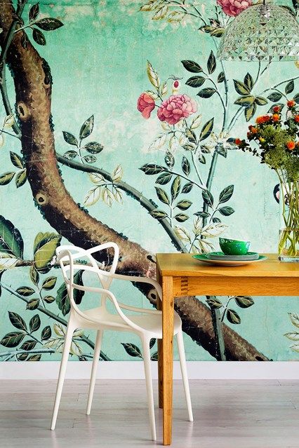 A dining room with a unique green wall mural.