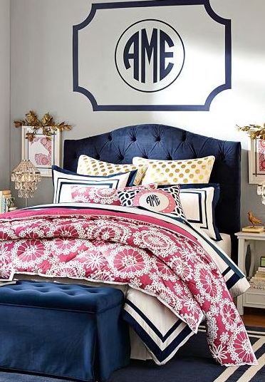 A bedroom with a monogram on the wall adds a personal touch.