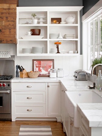 Neatly stacked items in open kitchen shelving 