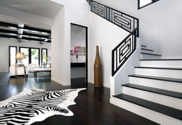 A monochrome home with a zebra rug on the stairs.