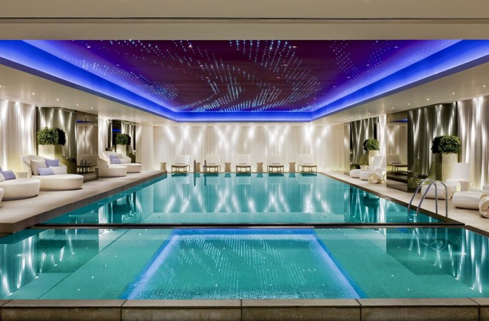A home with an indoor swimming pool in inspiring blue lighting.