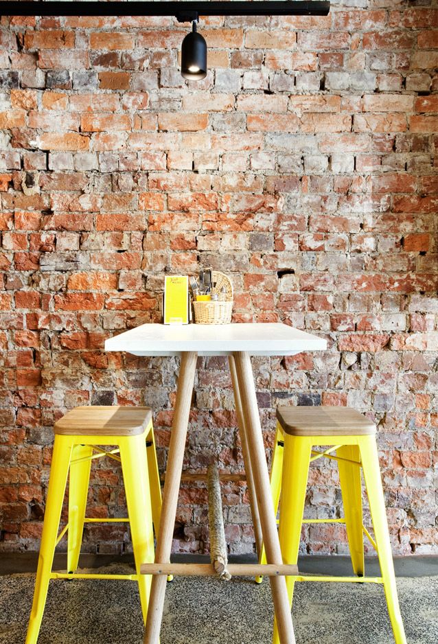 Yellow accents are placed in the spotlight by a warm brick wall (79ideas.org)