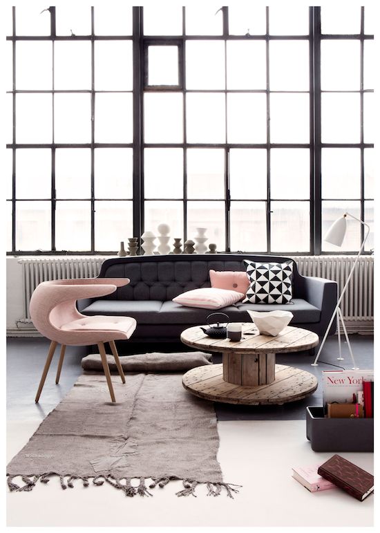 A modern living room with a black couch and a pink coffee table, perfect for the modern woman.