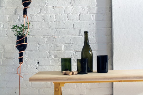 A table with hanging wine bottles transformed into a herb garden.