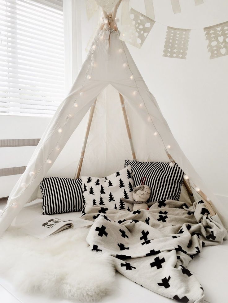 A cozy retreat in a child's room, featuring a white and black teepee.