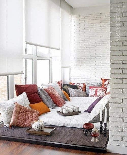 A cozy living room with a couch and pillows in front of a window, providing a comfy retreat.