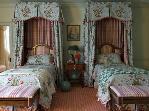 Two twin beds in a room with floral curtains.