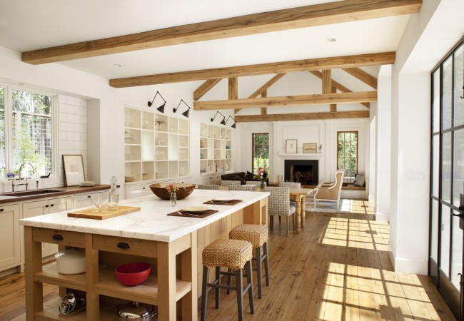 A modern farmhouse kitchen with wood beams and a large island.