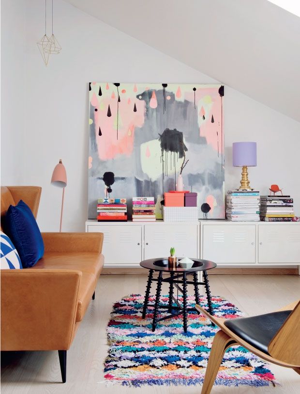 A modern living room with a colorful painting on the wall.