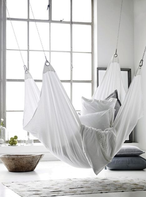 A comfy retreat featuring a white hammock and a window.