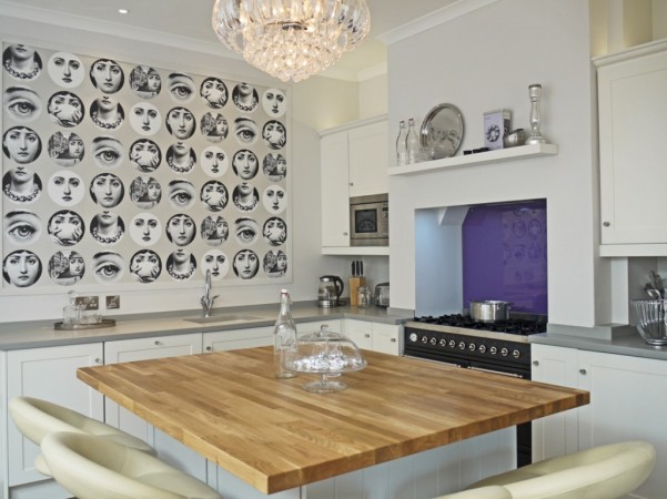 A kitchen with Piero Fornasetti plates on a table.