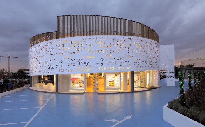 A circular white building with a perforated design.