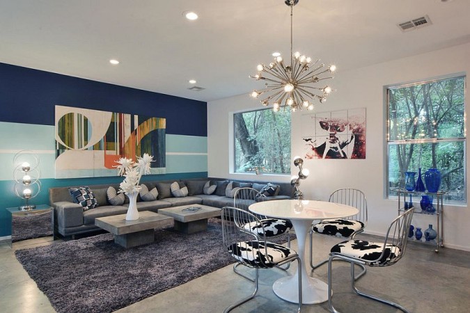 A living room with bold blue and white walls and a table and chairs.