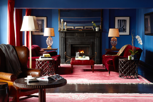 A blue living room with a fireplace and a rug.