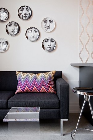 A living room adorned with Piero Fornasetti plates.