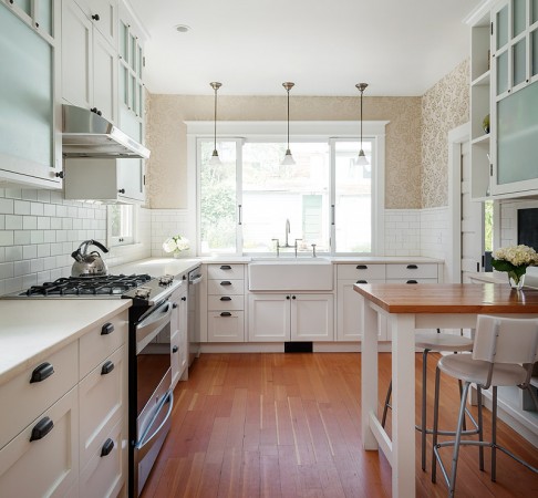 An apron sink and hardwood floors accent this modern farmhouse kitchen
