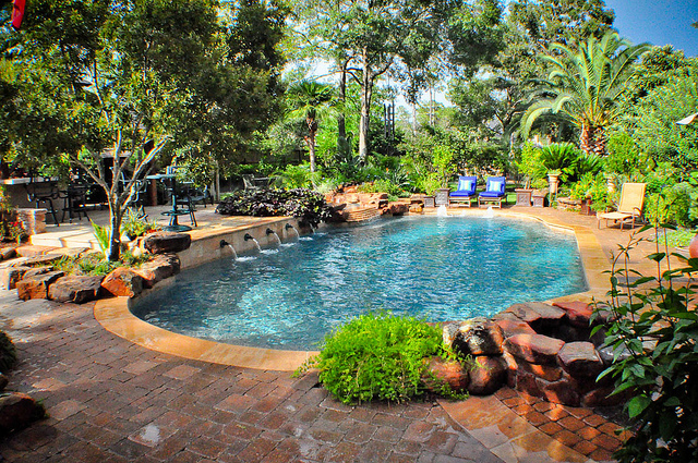 A lush landscape accents this swimming pool 